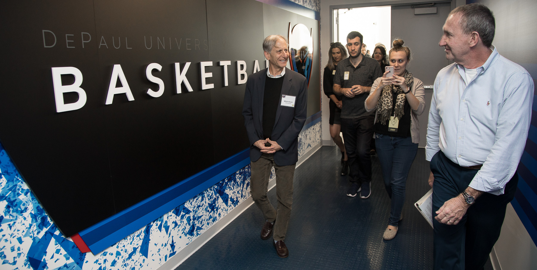 Mitchell Hirsch, principal architect for Pelli Clarke Pelli Architects, left, and Bob Janis, vice president of facility operations, lead attendees into DePaul's basketball suite. (DePaul University/Jeff Carrion)